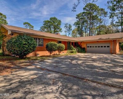 4141 Lake Ave. Mid-century 4 Bedroom 2.5 bath brick house with 2 car garage, and a circular driveway sitting on a 2.4-acre lot located in the heart of Wilmington. The foyer greets you with LVP flooring and a geometric bookcase that has a retro built-in beverage cooler in the living room, leading to the den which is separated by a double-sided decorative fireplace, and a beautiful all-season sun...