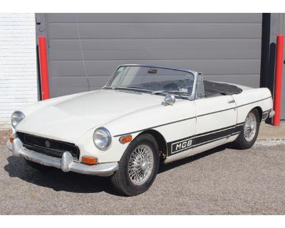 Odometer: 129000. A 1963 MGB Roadster. Built in 1962 and the first year of this model. Pull handle. Wire wheels. A matching numbers car. White with a black interior. 129,000 miles. A good body. There is some rust underneath as you can see in the pictures. The paint is old. The original interior is all there but showing its age. The soft-top is in good condition. Comes with a tonneau cover, spar...