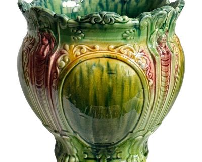 Antique Majolica jardiniere planter. This style features a high-relief, Art Nouveau design with a blended 'drip' majolica glaze, combining green, yellow ochre and burgundy tones. Scroll forms and shield motifs with lion's feet at base. Consistent crazing throughout. No cracks. Item is unmarked.. Dimensions 10.2 W 10.2 D 10.5 H Styles Art Nouveau Period Early 20th Century Country of Origin Unite...