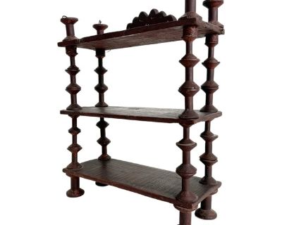 Antique tramp art wood shelves made of stacked sewing spools strung together with steel wire, accented with a scalloped panel detail on top. Painted in a deep brown with burgundy undertones. The piece can stand on a surface or mount to a wall with the hanging wire on back.. Dimensions 14 W 5.5 D 18.25 H Styles Early American Folk Art Rustic Period Early 20th Century Country of Origin United Sta...
