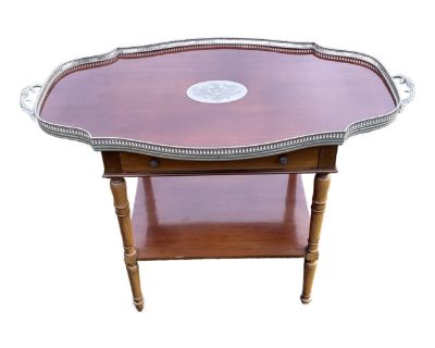 A truly unusual tray / table combination. UK / British market, 20th Century. Beautiful dark finish solid wood, with finely crafted white metal trims, borders and pulls. 45" wide, 31" tall, 25" deep. Very detailed, heavy and well-executed. * One drawer - dovetailed, and deep - perfect for linens and cocktail accessories. * Beautiful and detailed pulls * Tray top with large finely engraved center...