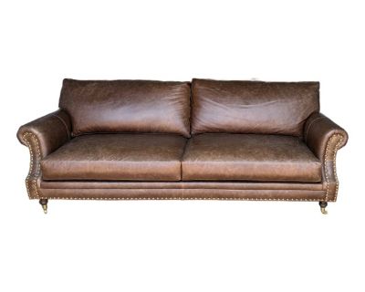 Custom-made in LA by The Joneses in 2023 to replicate the iconic Holkam couch from England s House of Chesterfields. Beautiful Tuscany leather in a rich cacao color. 96x42x34 with walnut finish turned legs and brass casters. Brass upholstery nails finish the look. EXCELLENT CONDITION. Can provide more photos if needed. It got taken to storage before I could snap any details/back pics, but the p...