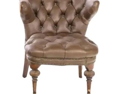 Victorian Style Tufted Brown Faux Leather Reading or Cockfighting Chair with pleated deep button back and arms. Seat has tan piping on arms and back and brass studding on seat. Chair is supported by slightly out-swept legs, the front legs have brass casters and the back wooden legs are tapered. Historically, these chairs were placed in arenas where spectators would gather to watch the fights, o...