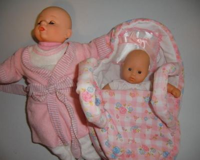 Baby dolls in fabric carrying bassinette