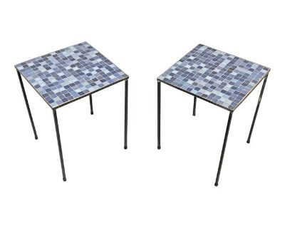 A pair of Italian side tables with Murano glass inset tiles. This design is often associated with the American importer Raymor, which exported goods from various Scandinavian and Italian factories to the United States from the 1940s until 1980. This pair, with various shades of blue toned tiles, were most likely brought to this country by a visitor to the Venice region of Mestre, as they both b...