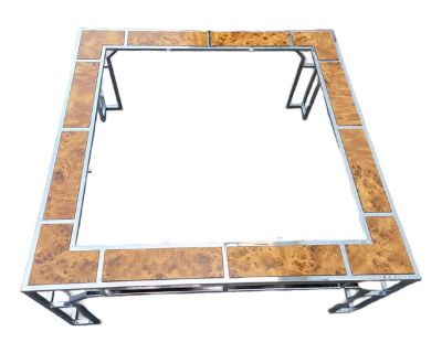 This stunning coffee table is a vintage mid-century beauty with a chrome frame and burl wood accents. The design is in the style of Milo Baughman for companies such as Thayer Coggin or the Pace Collection, which were popular in the 1970s. The table features a square shape with a polished chrome base and a top with a glass insert, surrounded by panels of burl wood.. Dimensions 36 W 36 D 16 H Sty...