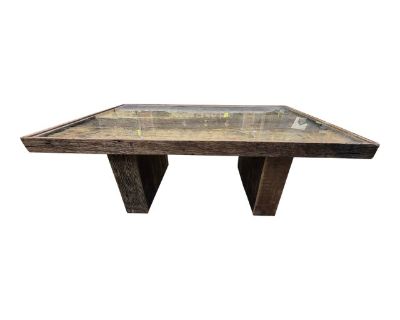 The Solid Reclaimed Wood Coffee Table with Glass Top is a stylish and rustic addition to any living or dining room. Made with a light wood tone and featuring a rectangular shape, this indoor coffee table has a unique combination of a glass tabletop and textured finish. The table is 47 inches long, 18 inches tall, and 32 inches wide, providing ample space for coffee, books, or decor. With its or...