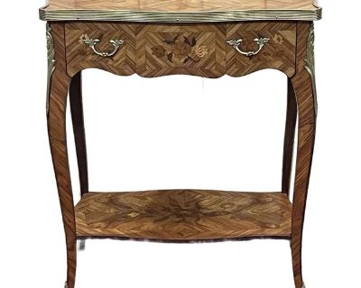 Stunning French side table with detailed inlay. Made of rosewood, this table features wonderful, detailed floral inlay on top and all sides. Bronze d ore hardware adorns the parameter of the table top, the legs, and the drawer pulls. This piece is in pristine condition. Imported from France.. Dimensions 22.5 W 13.4 D 26 H Styles French Hollywood Regency Table Shape Rectangle Period 1950s Countr...