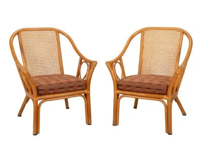 A stylish pair of Mid-Century bamboo and cane side chairs that bring an easy coastal elegance to any space. The sculptural bamboo frames feature caned backs in excellent condition with no breaks, and the plush cushions are clean and well-kept with no staining. Measuring 28 W x 25.5 D x 34 H with a seat height of 17 , these chairs offer both comfort and visual appeal. The design blends beautiful...