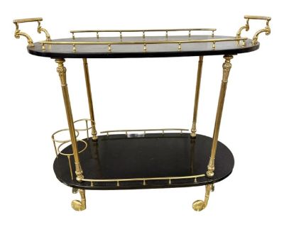 Crafted in the mid-century, Tura s iconic design features luxurious black lacquered shelves complemented by exquisitely cast brass rails, column legs, and handles. The elegant dual-tiered structure offers plenty of space for barware and bottles, with raised brass galleries on both levels to keep your treasures secure. While Tura passed away in the 1960's, his iconic bar carts only became more c...