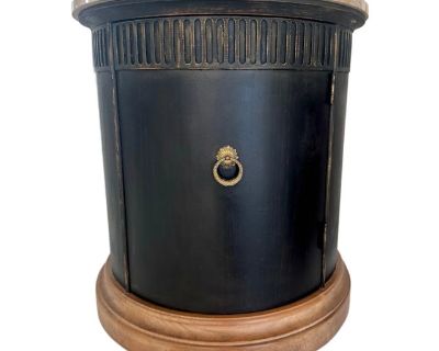 Elevate your space with this striking round cabinet featuring a polished marble top, rich black finish, and warm wood base. The detailed carved apron with vertical fluting brings a refined touch, while the brass lion s head pull adds a hint of classical charm. Perfect as a side table, end table, or accent piece, this cabinet combines functionality with timeless elegance. The round design makes ...