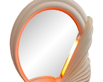 Step into the luminous world of 1980s Italian design with this dramatic illuminated mirror. Sculptural and sleek, its fan-like form in glossy white lacquer is pure postmodern fantasy part seashell, part sunrise. A built-in pink light glows softly behind the mirror s edge, creating a warm halo effect that instantly evokes the playful glamour of the Memphis movement. Designed and made in Italy, t...