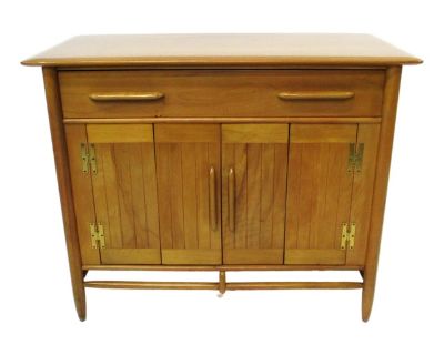 A very well-crafted Mid Century solid Northern Birch wood credenza sideboard with bi fold doors having a fixed shelve. The upper drawer with long matching pulls has divided areas for storage, solid brass hardware and great graining to the wood. Manufactured by the Cushman Furniture company, North Bennington Vermont from their Cushman Contemporary collection designed by John Lubberts and Lambert...