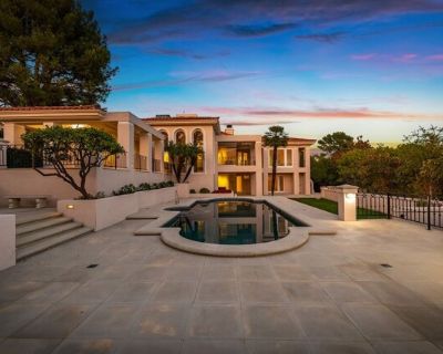 1136 Calle Vista Dr. Commanding a premier position atop a coveted promontory on Billionaire's Row, this private nearly acre estate, designed by the esteemed architectural firm Benton, Park and Candreva, is a warm contemporary villa showcasing extraordinary panoramic views from Century City to the Pacific Ocean. A gated front courtyard leads to a grand entrance with soaring ceilings that opens t...