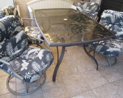 Glass top patio table w/ four swivel chairs, cushions included. Seats six.