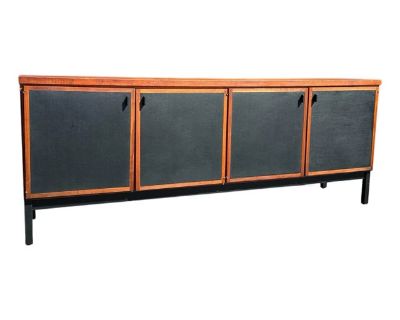 Mid Century Modern Credenza designed by Jack Cartwright for Founders Furniture. Part of the Patterns 10 collection in oil rubbed Walnut with black leather door panels and ebonized legs. A timeless classic design that would blend well with a variety of styles. Four doors, right side has two felt lined drawers and open storage, right has open storage with one shelf. Stamped on back 52305-02 which...