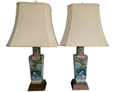 A pair of Chinese, famille verte, porcelain vases converted to table lamps. These mid-century , timeless , Chinese export lamps have hand painted peony motifs mirroring each other, whereby each side of the lamps have a different decoration. The colors are stunning. The lamps are set on a wooden plinth, have a brass cover, have matching octagonal, ivory pagoda lamp shades with a whimsical, origi...