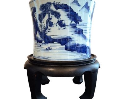 Chinese porcelain landscape bitong, a finely formed brush pot with gently sloping sides, a white glazed interior and circular inset centered on the unglazed base. The body of the pot is decorated with a finely drawn, blue and white landscape with distant mountains, a waterfall, and rivers and lakes, featuring a boatman, three picnickers and two travelers amid trees, pines and shrubs. The landsc...