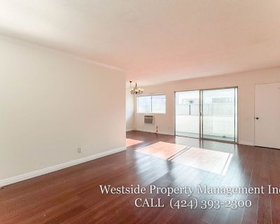 1827 S Barrington Ave. This bright and spacious upper-level condo features an open living room with a wall A/C unit, plenty of room for a dining area, and access to a south-facing private balcony. The kitchen is well-equipped with ample cabinetry, a stove, dishwasher, and refrigerator. A hallway offers additional storage and leads to a full bathroom. The first bedroom includes access to a share...