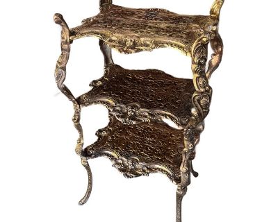 This late 19th-century rare antique brass and metal three-tiered piece serves as a plant stand or accent table, featuring exquisite engravings and ornate decorative cherub figures. Measures 32" High, 17" Wide, 13" Deep Crafted from durable brass & metal Multi-functional as a plant stand or accent table Intricate engravings & decorative figures enhance its antique charm Light wear, tarnish, and ...