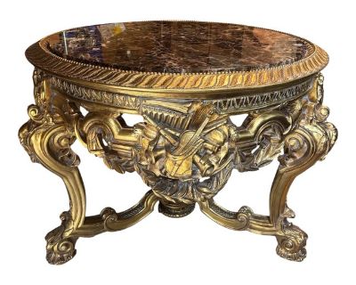 Add a touch of elegance and sophistication to your center hall or any living space with this stunning Asnaghi Interiors hand carved giltwood table with a gorgeous brown marble top. It is carved around the top and the marble is set inside. The large apron is adorn with musical instruments and a leaf garland. There are 3 Louis XV style legs with a beautiful center decoration. This hand carved cen...