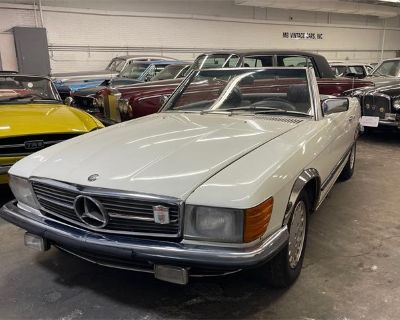 Odometer: 130111. A 1984 Mercedes Benz 380SL Roadster. White with a navy-blue leather interior. Euro specs car equipped with European headlights and bumpers. Two tops, automatic transmission. 130,000 miles. A nice straight body. Overall solid undercarriage. The paint is old and faded. The original interior is all there, but there are some cracks and needs to be redone as you can see in the pict...