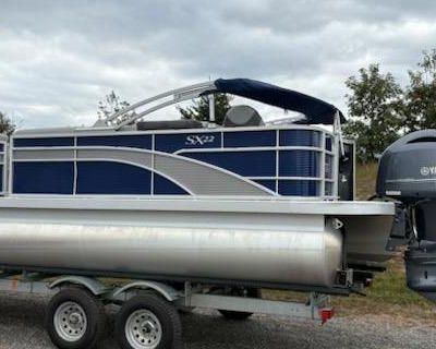 Introducing the stunning 22 S Stern Fish boat, designed for fishing enthusiasts who appreciate both style and functionality. This model features a sleek metallic silver exterior, complemented by a luxurious silver Simtex vinyl base and elegant Zwood slate matte accents. Equipped with practical amenities, it includes a convenient cupholder with a pocket, toe-kick lighting, and an RGB control gau...